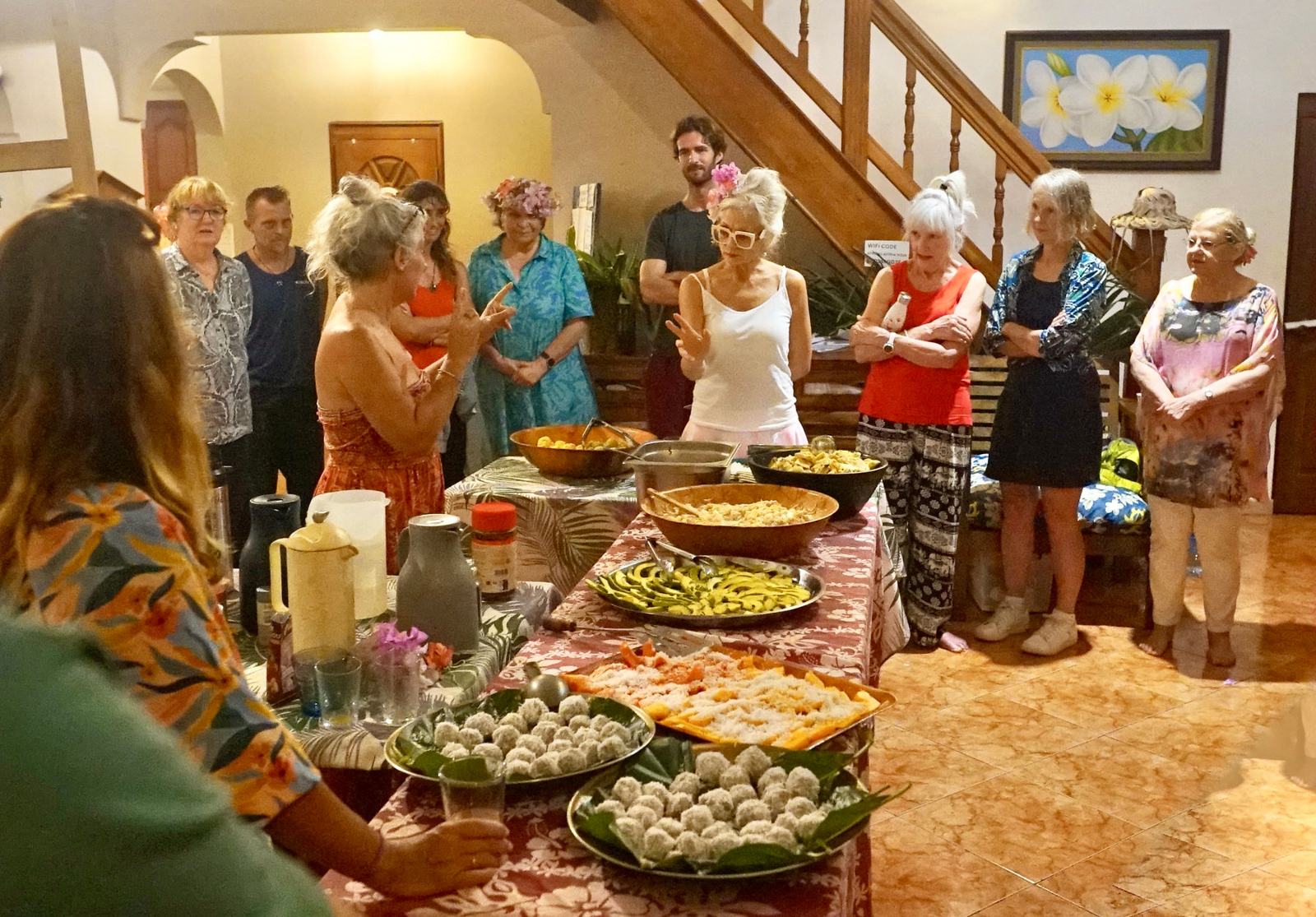 Guests gathered around a table of Polynesian dishes at Fare Om